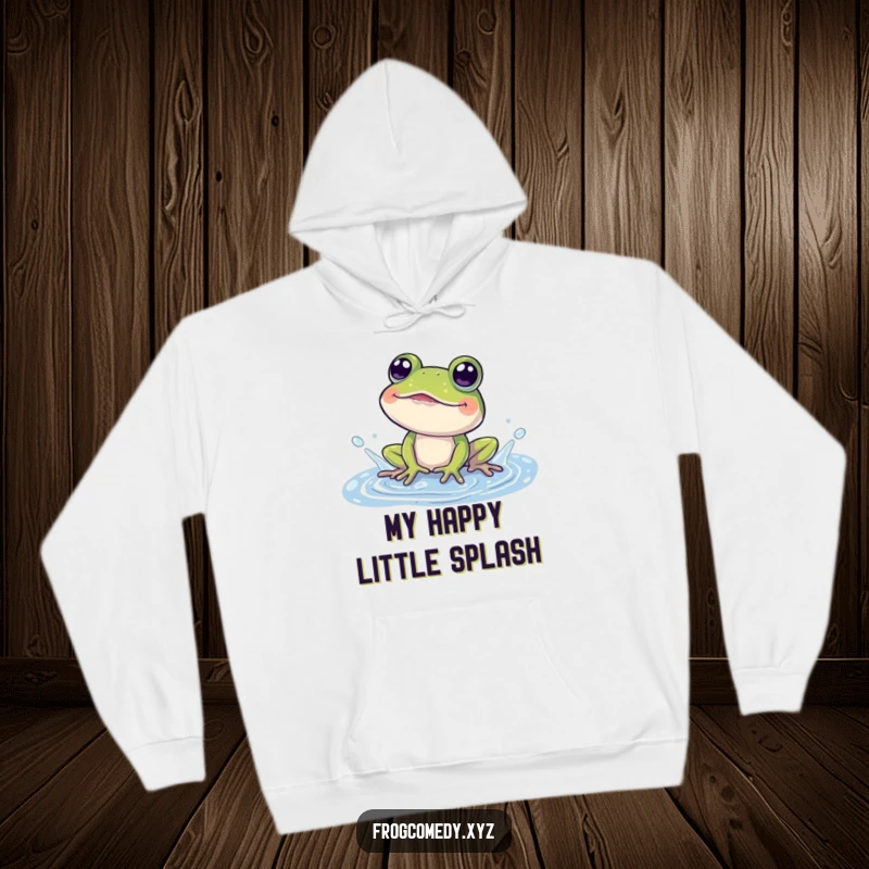 Funny hoodie with a cute frog character gleefully splashing in a puddle, eyes wide with amusement.