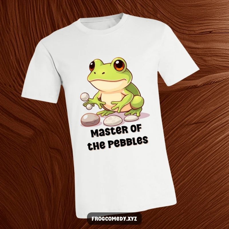 Funny t-shirt featuring a focused kawaii frog artistically juggling three small, gleaming pebbles, highlighting its funny determination and skill.